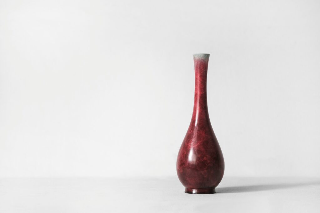 Long slender vase behind a white background